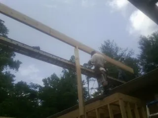 Carpenter setting a ridge beam over a new addition frame — Ice Dam Removal by Roofing Brothers in Greenwood Lake