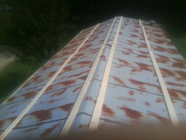 Rusted metal roof panels with new wood purlins before replacement — Storm Damage Roof Repair in Greenwood Lake by Roofing Brothers