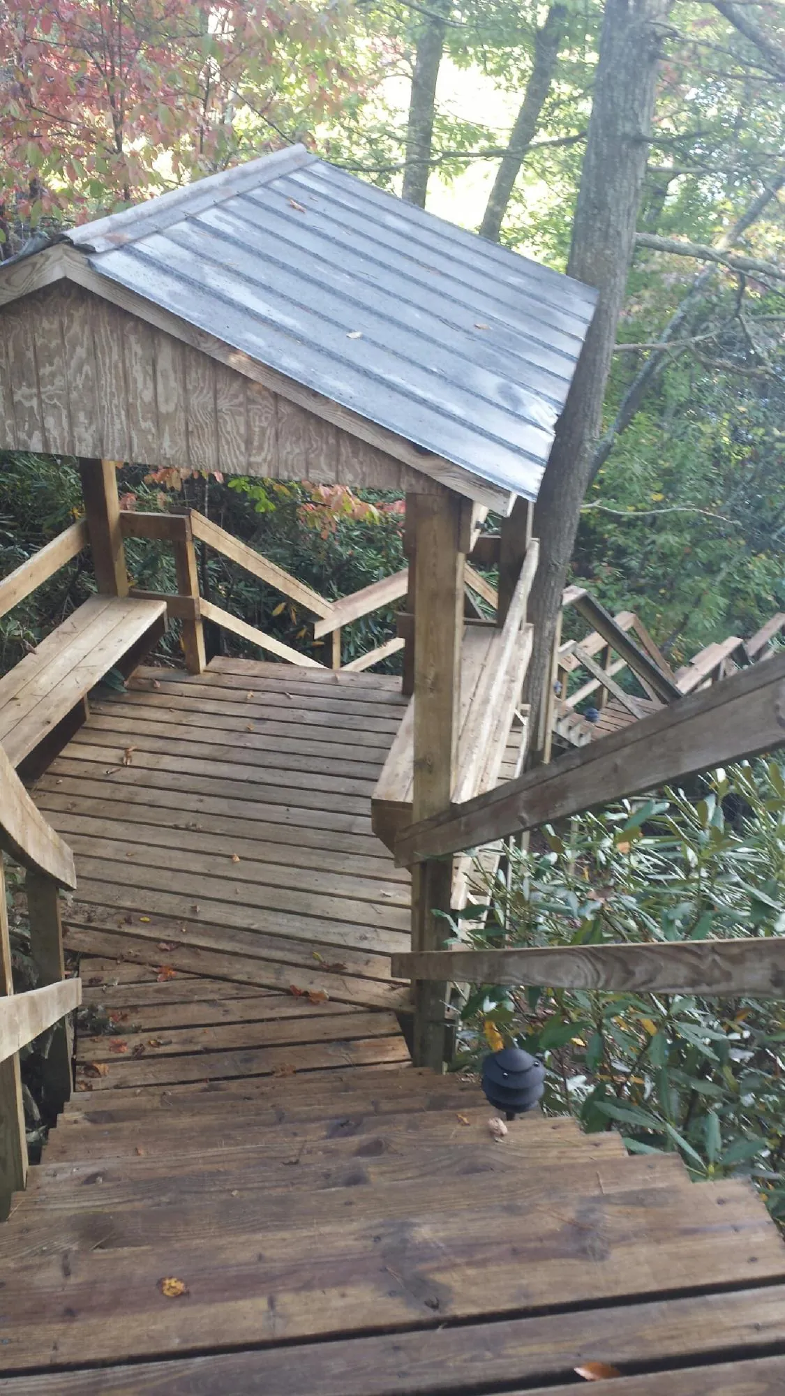 Metal roofed shelter over wooden steps on a wooded walkway — Skylight Repair & Installation work by our crew in Greenwood Lake