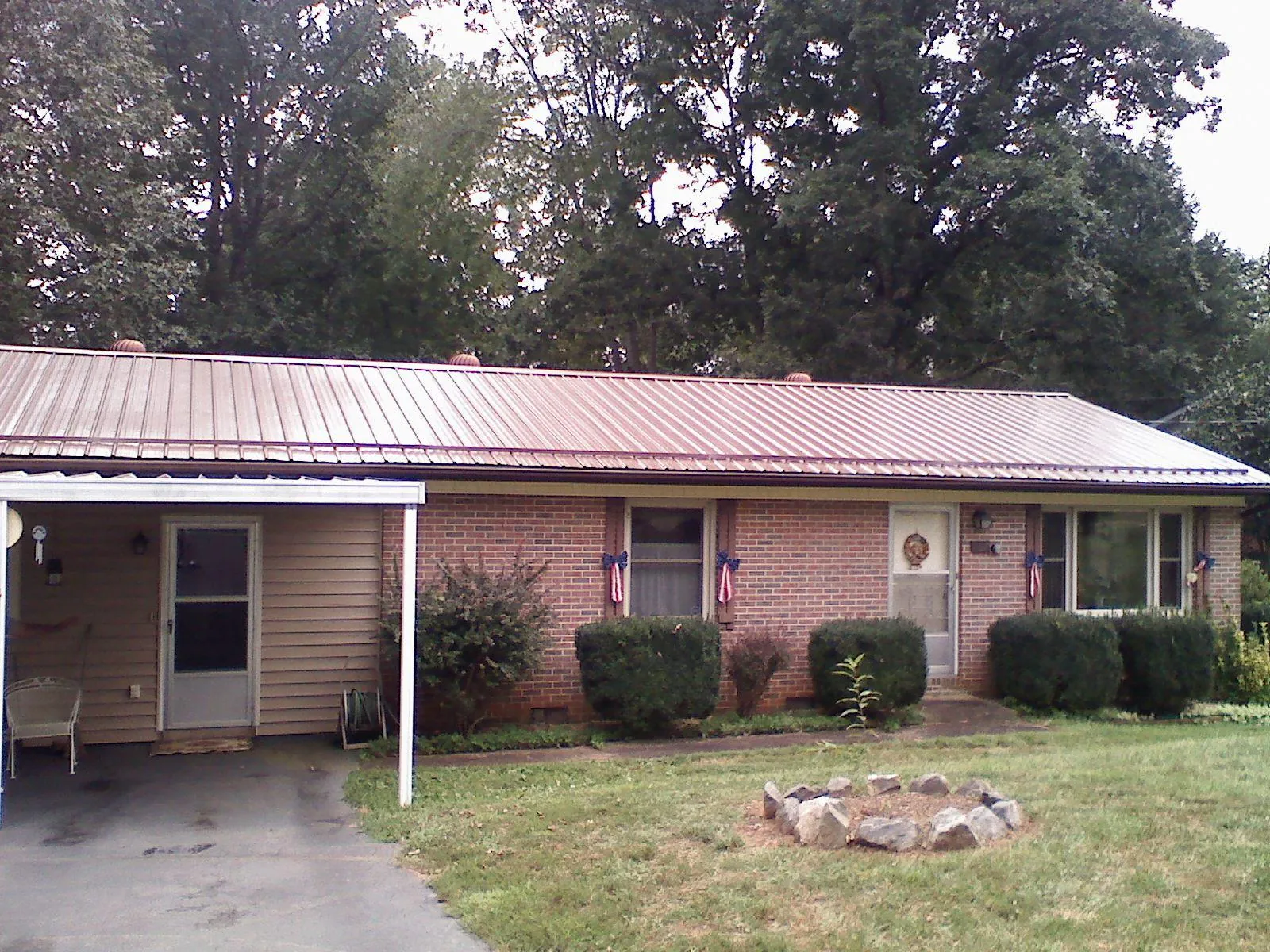 Bronze metal roof and carport on a brick ranch home — Roof Repair work by our crew in Greenwood Lake